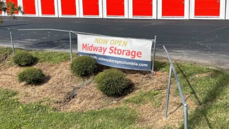 Banner say Midway Storage is now open in front of the storage facility.