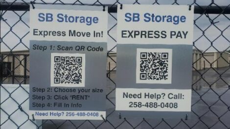 Signs on gate one for express move in with QR code and one for express pay with QR code at SB Storage in Tuscumbia.