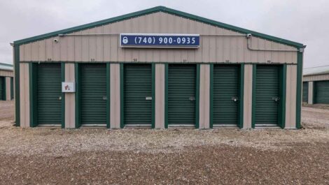Storage unit building with phone number sign attached at Premier Storage- New Albany.