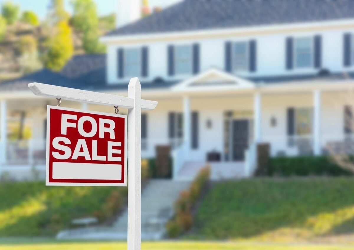 A for sale sign in front of a house.