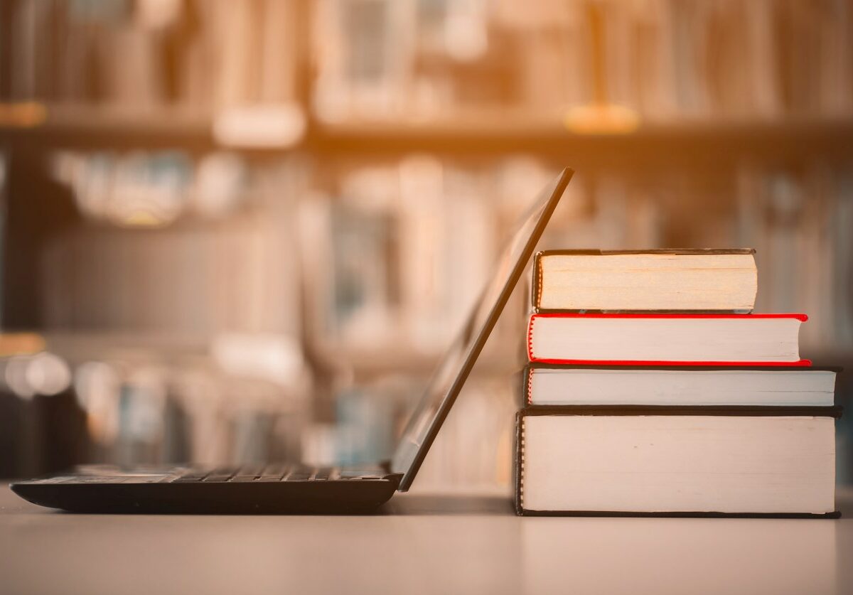 A laptop leaned up against textbooks ready to be packed.