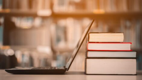 A laptop leaned up against textbooks ready to be packed.