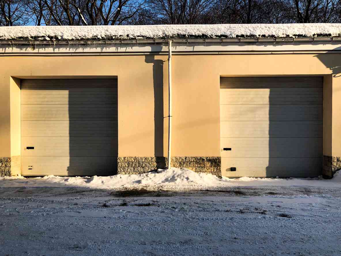 Two storage units side by side in the winter, with snow on the ground out front.