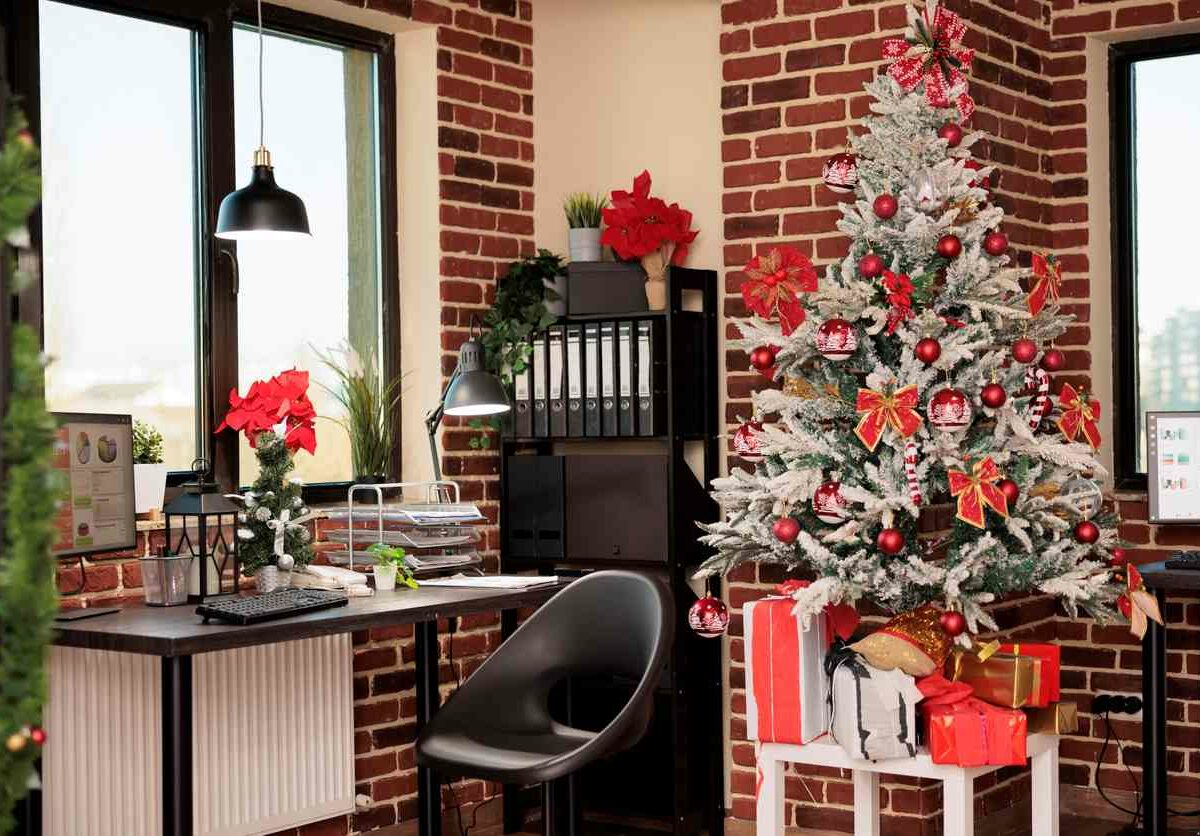 A small office decorated for the holidays with a tree and presents