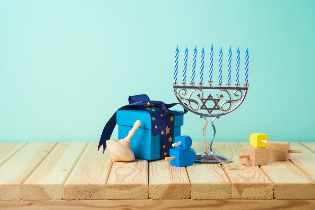 A series of menorahs and Hanukkah decor items set on a shelf for storage
