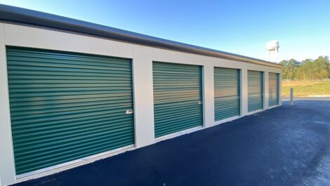 Outdoor storage facility units with green doors.