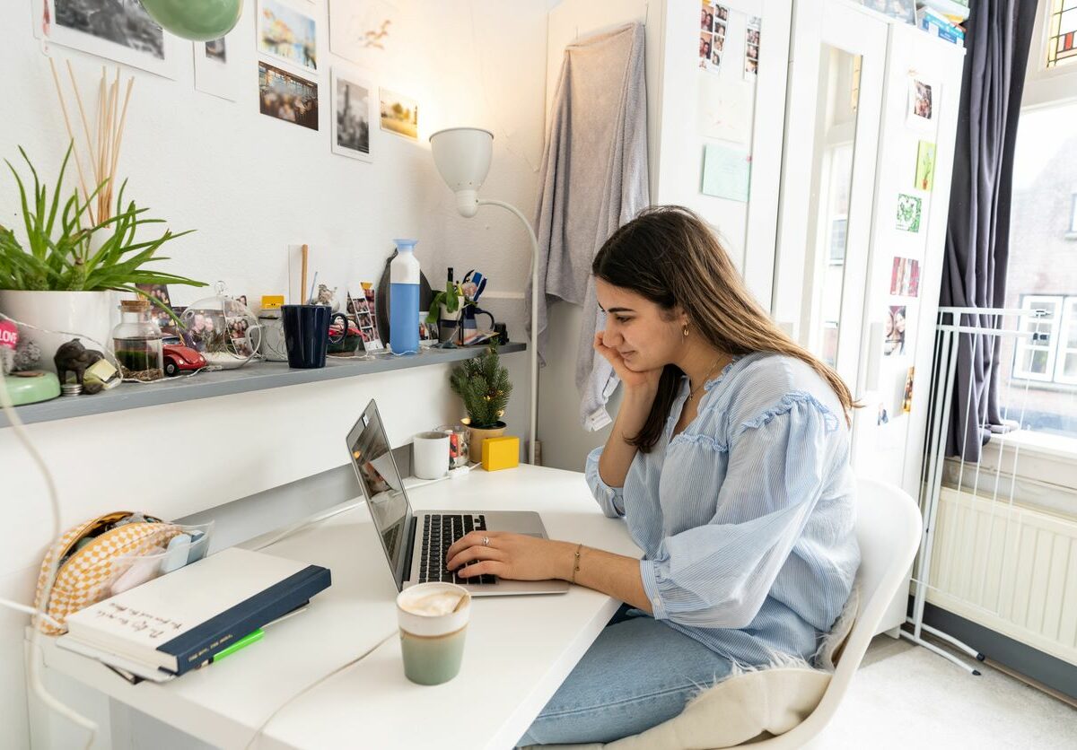 College student using laptop in her dorm.