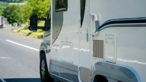 A motorhome driving down the road during the day