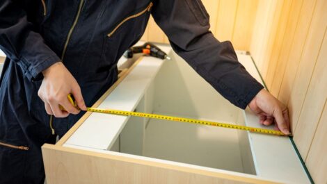 Male hand furniture assembler using tape measure stock photo