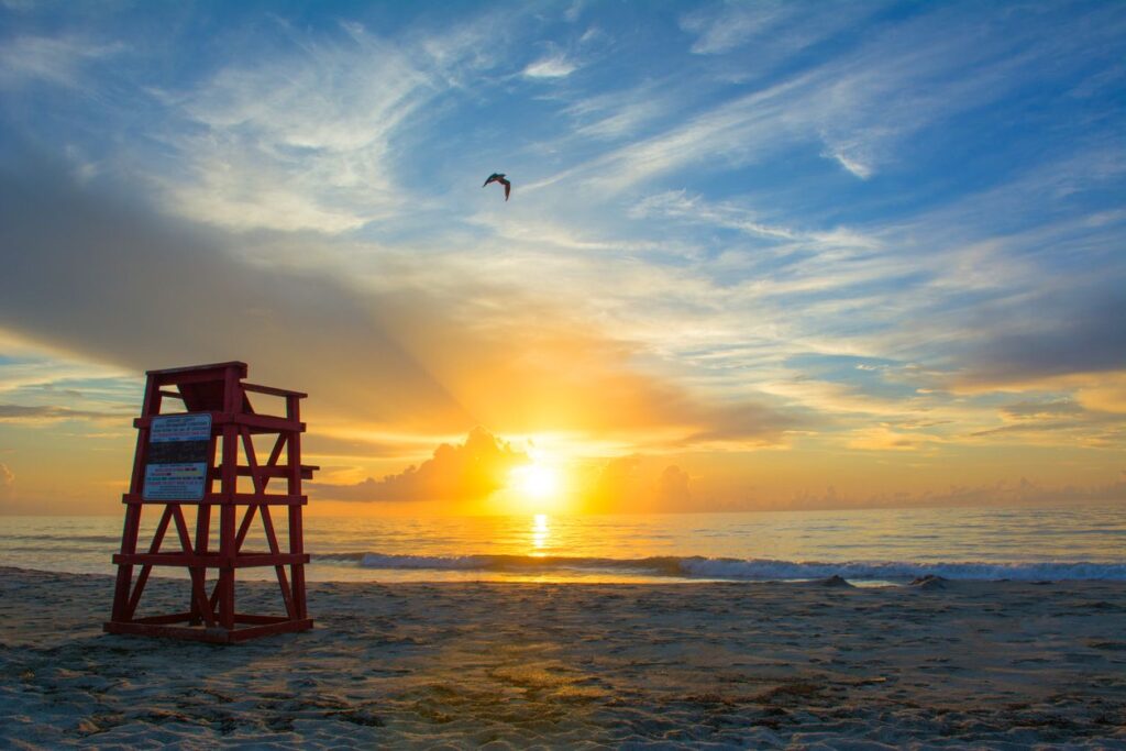 The sun rises over the sand at beautiful Cocoa Beach in Florida.