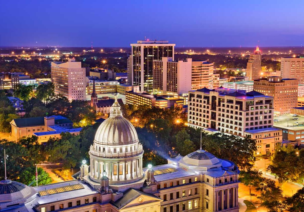 The downtown Jackson, MS, skyline at dusk with the Mississippi State Capitol building.