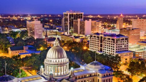 The downtown Jackson, MS, skyline at dusk with the Mississippi State Capitol building.