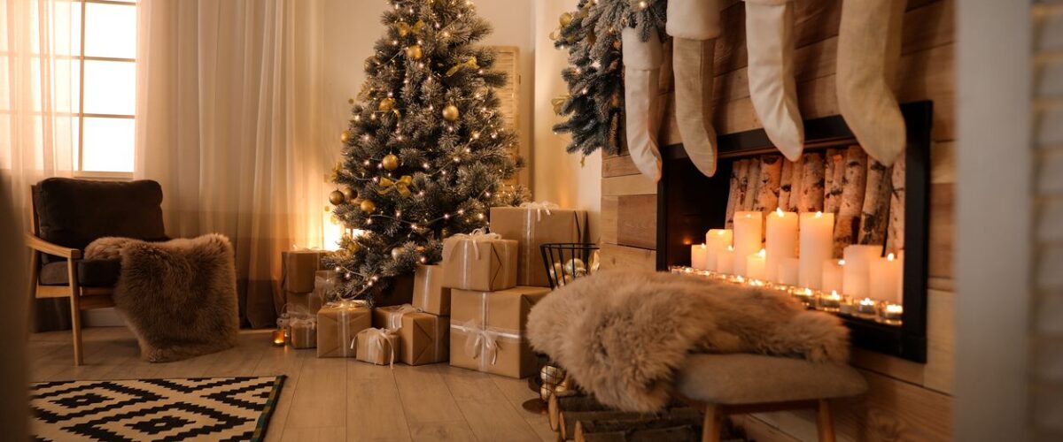 Festive living room decorated with a Christmas tree with gifts underneath and a fireplace with stockings.