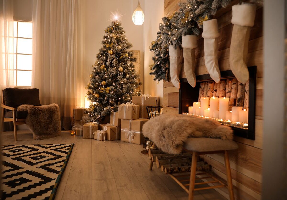 Festive living room decorated with a Christmas tree with gifts underneath and a fireplace with stockings.